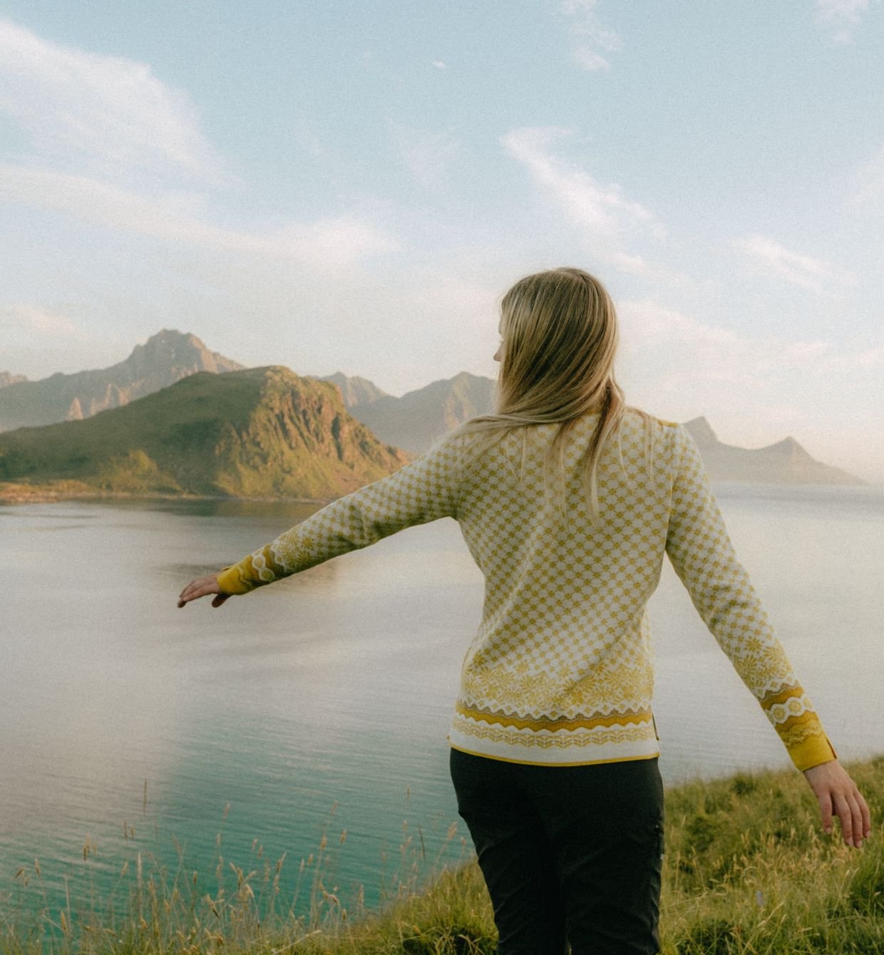 Danske Fie Agerskov i en gul ullgenser fra Dale of Norway ute i naturen i Lofoten