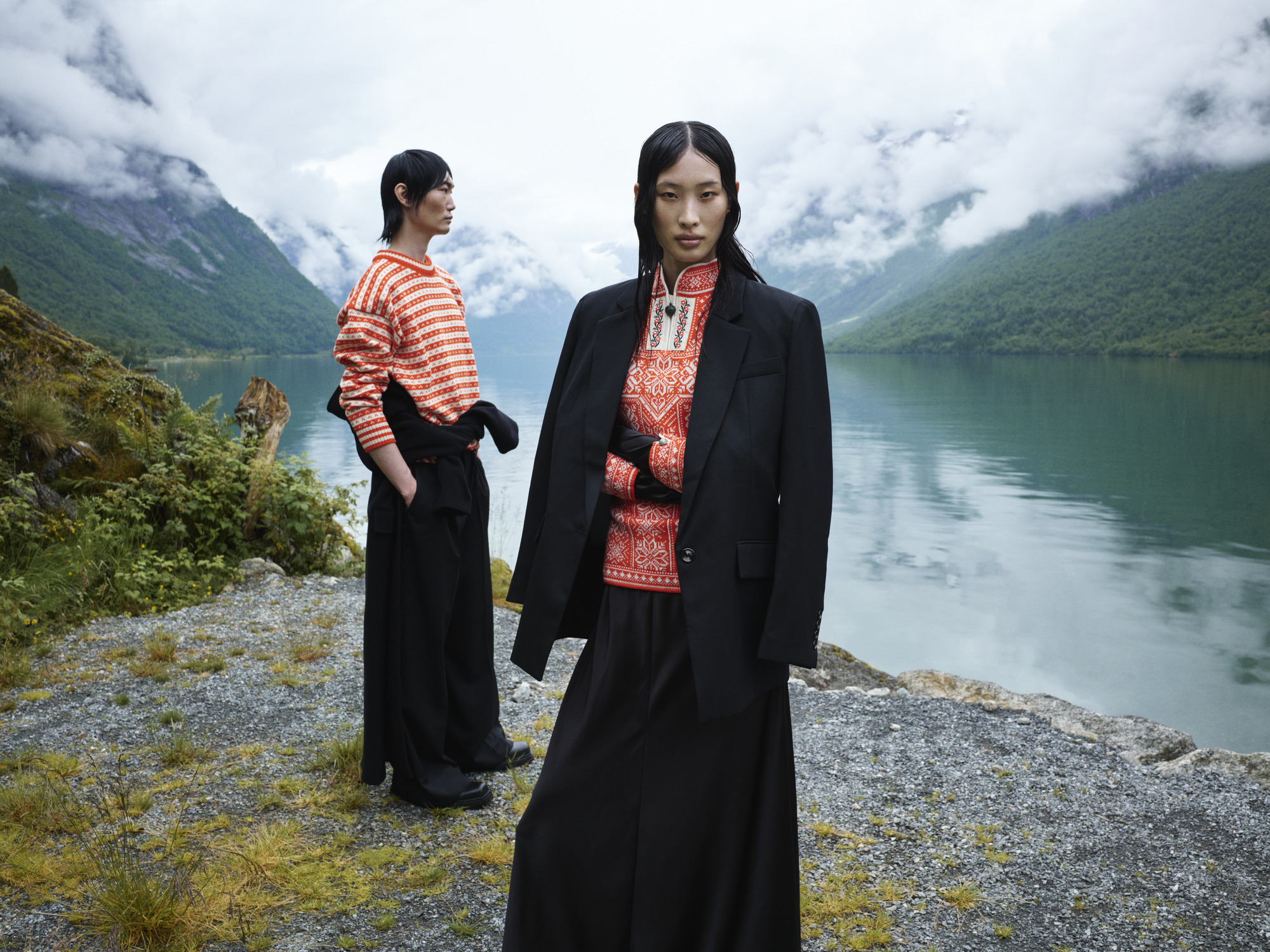 Oransje strikket genser ull p&aring; kvinnelig og mannlig modell i norsk fjellheim